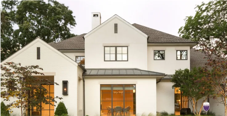 Maison blanche moderne avec garage et aménagement paysager dans la lumière du soir