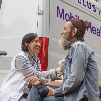 A mobile health clinic worker taking a patient's blood pressure