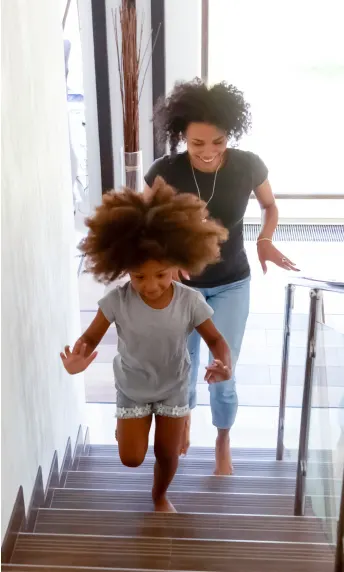 A TELUS Indoor Camera captures a family running up the stairs in the house. 