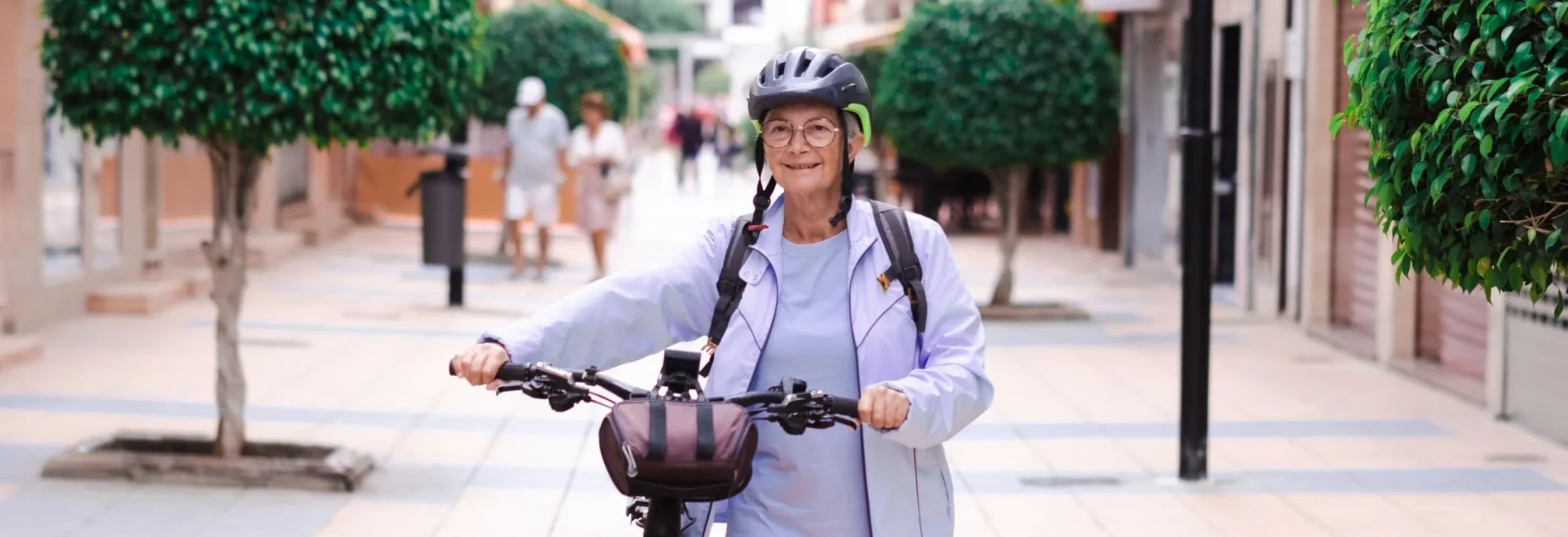 Senior woman walking with her bike.