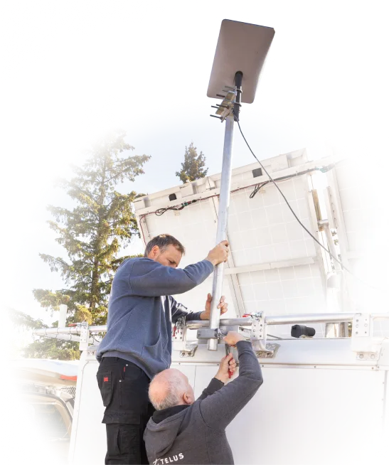 Two TELUS team members assembling an emergency cell tower