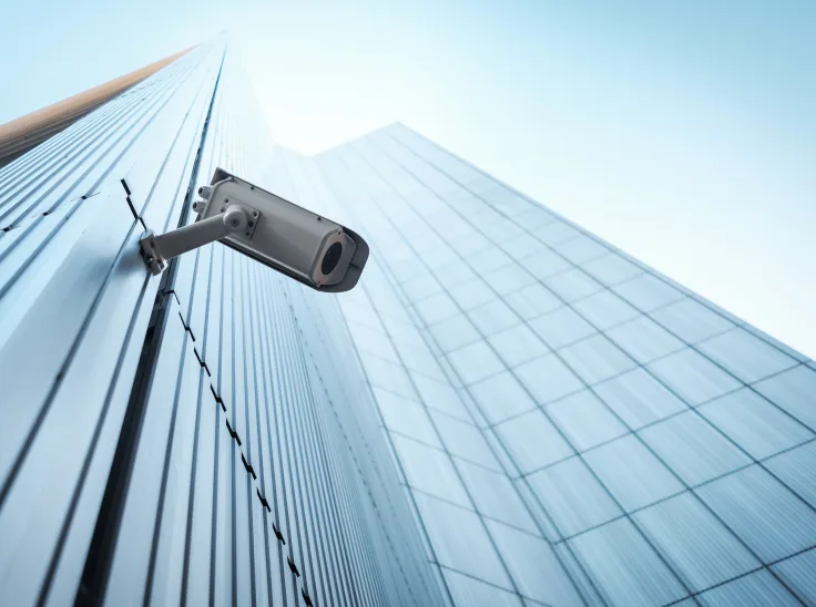 Security camera positioned on the outside of a commercial building.