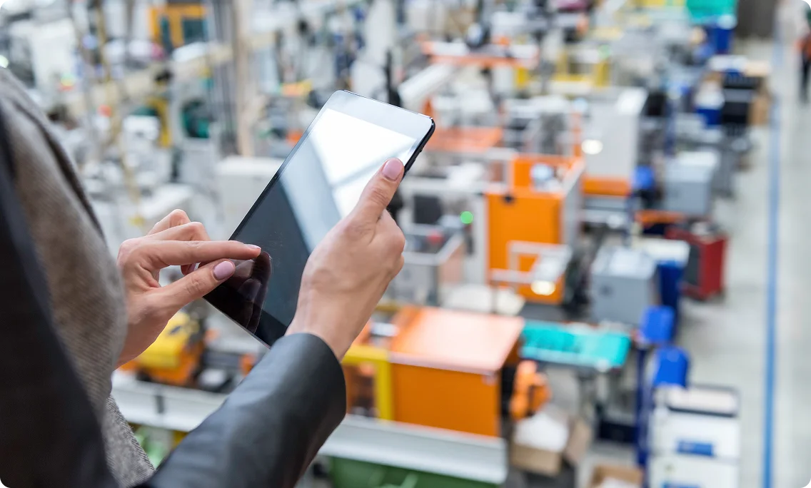 Manager using tablet for operations management in manufacturing facility