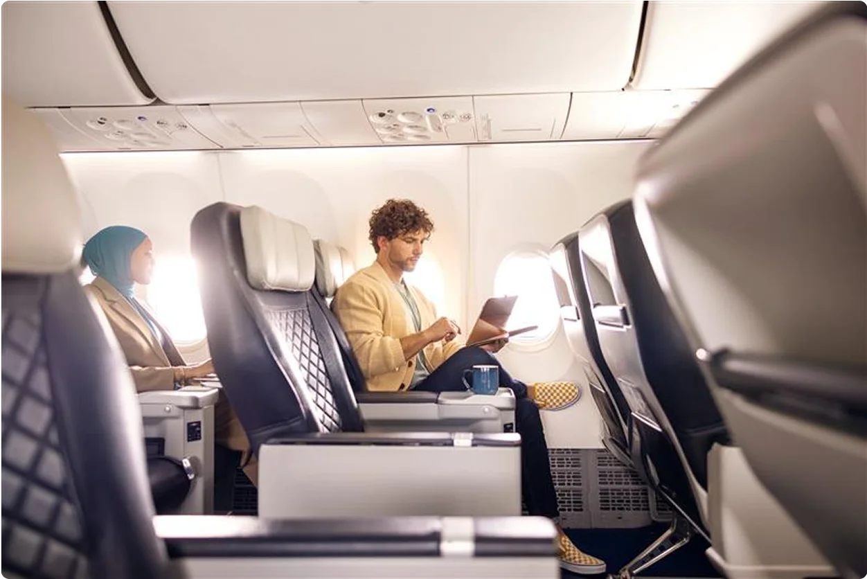 Un homme utilise sa tablette. Il est connecté au monde, même à 30 000 pieds dans les airs.