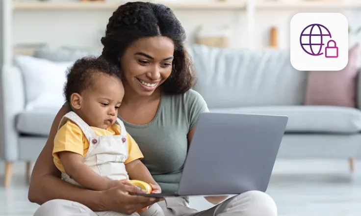 Une mère et son bébé assis en train de regarder un ordinateur portable.