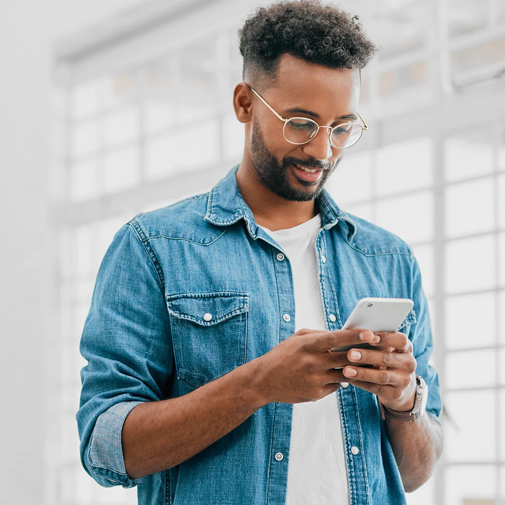 A young man using his smart phone to access health coach support.