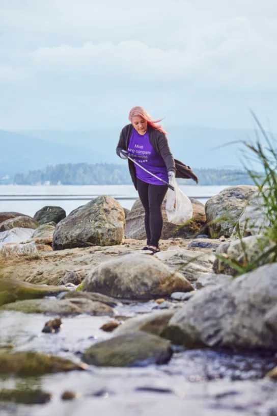 A TELUS team member cleaning up a shoreline