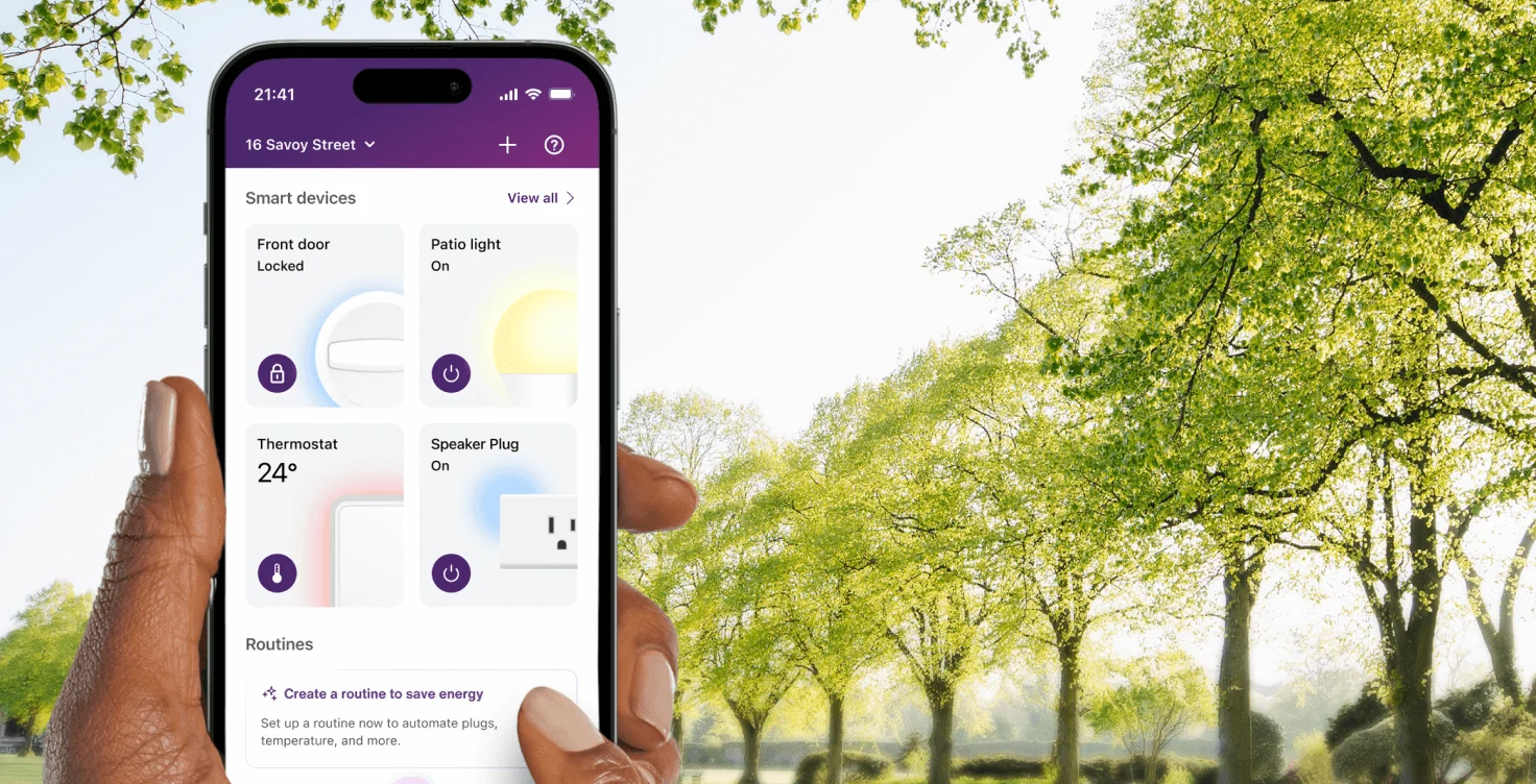 A hand holds the TELUS SmartHome+ app while out on a walk in the park showing the control of thermostats, smartplugs and routines.