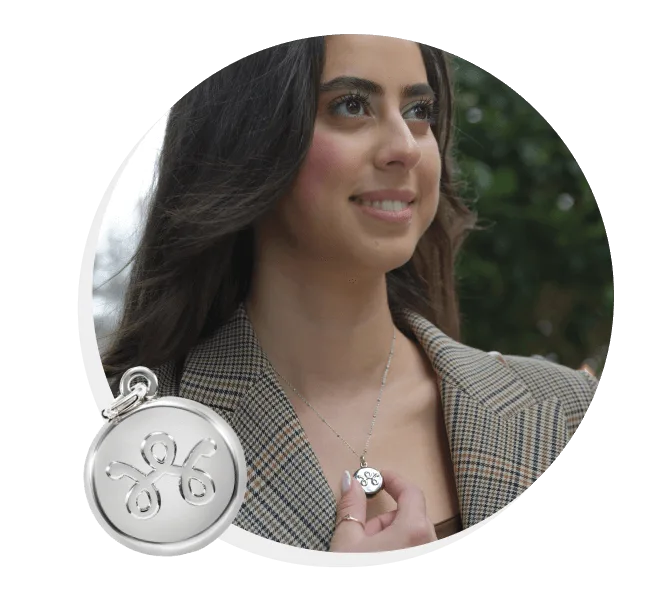 Woman wearing a plaid blazer stares ahead while wearing SmartWear necklace