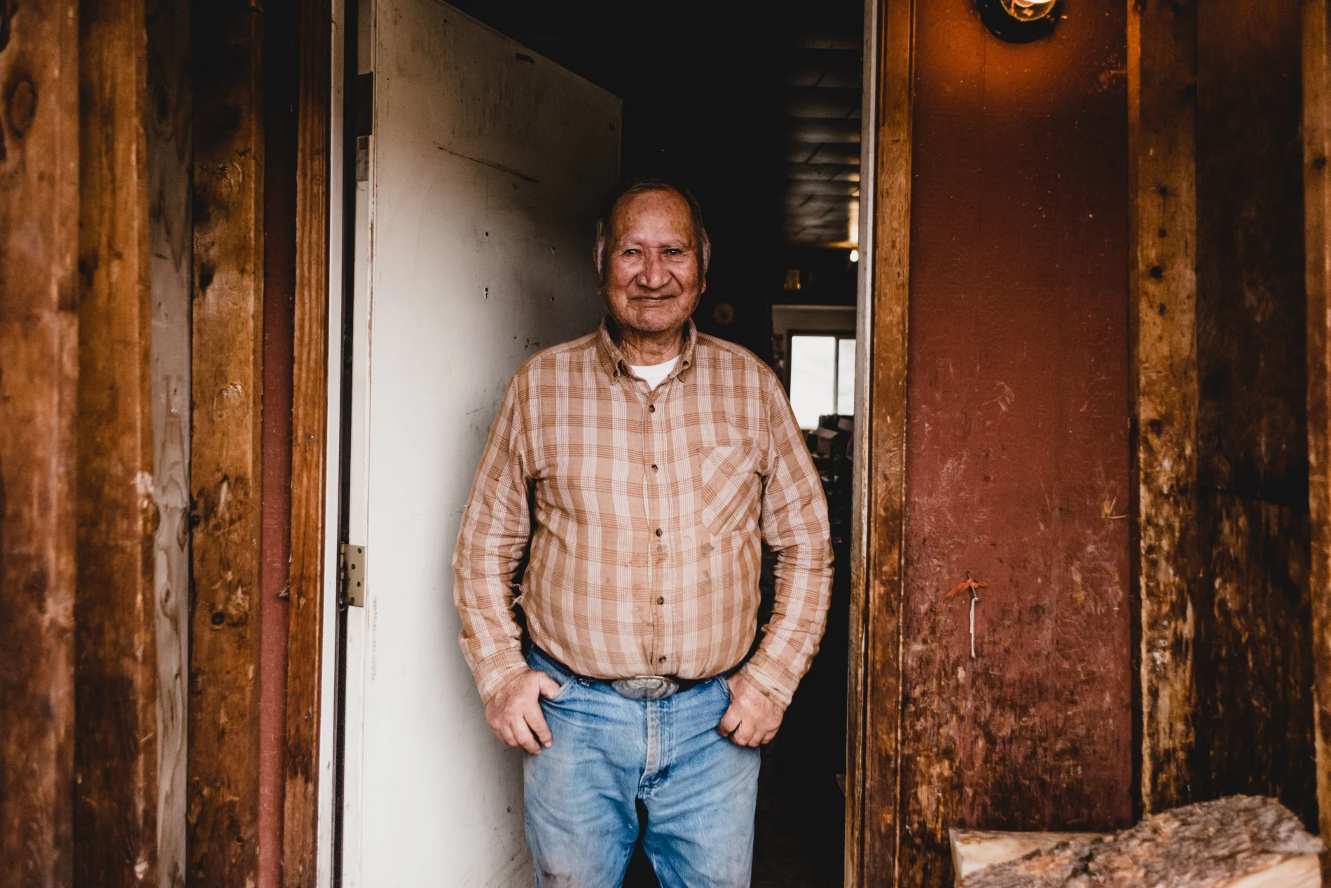 A middle-aged Indigenous man standing in a doorway