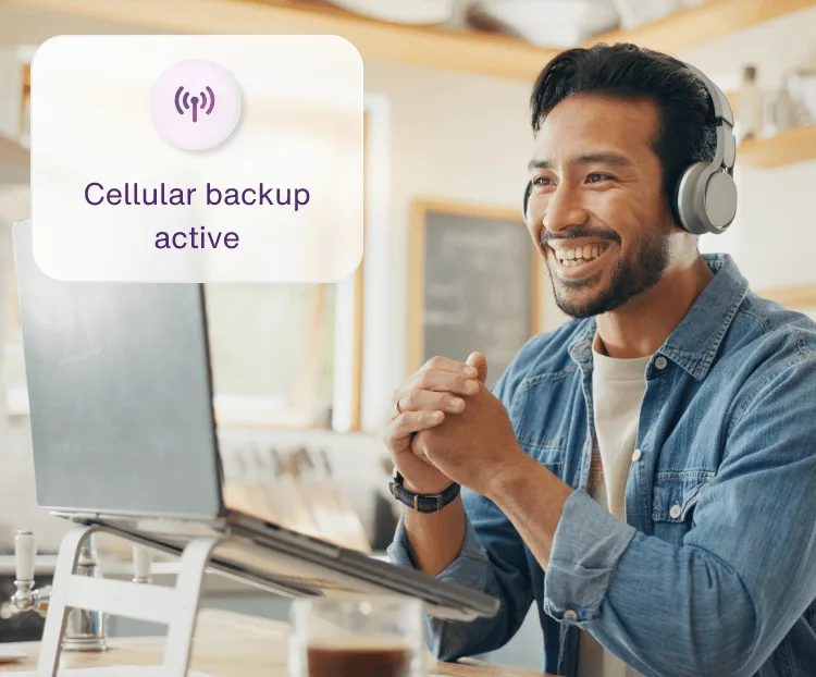 A man working from his laptop using Internet Backup during a home Wi-Fi disruption.