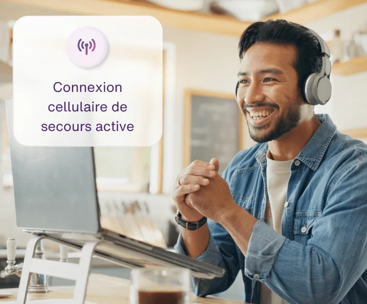 Un homme travaille sur son ordinateur en utilisant la fonction Connexion Internet de secours durant une interruption du Wi-Fi.