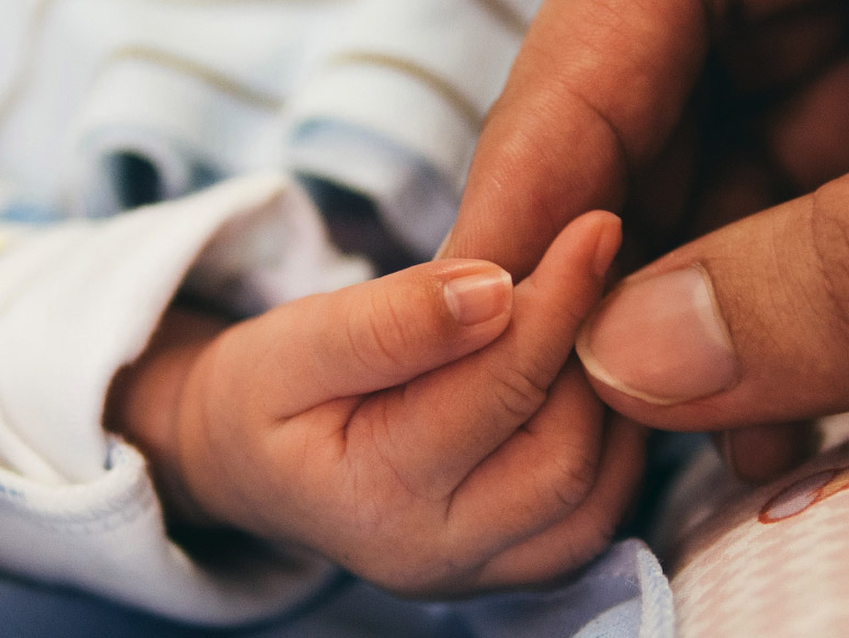 An image of a baby's hand.  The mother is touching the baby's fingers.
