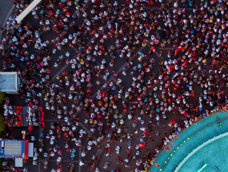 Aerial view of a crowd of people gathering around a blue stage. 