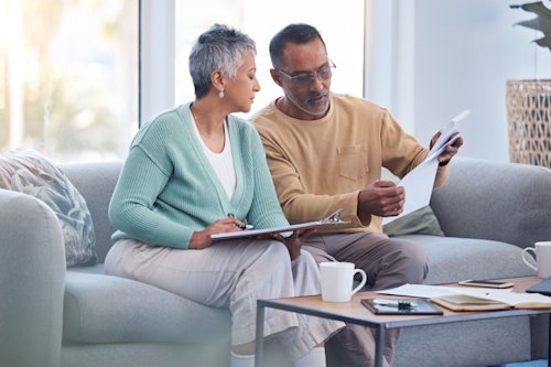 Finance, documents and senior couple on sofa with bills, paperwork and insurance checklist in home, life or asset management.