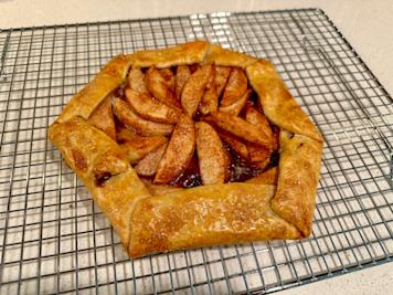 An apple galette on a baking rack.