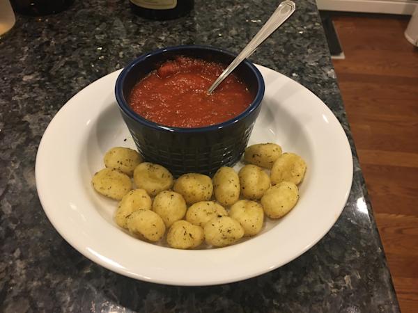 A dish of fried gnocchi with marinara sauce.