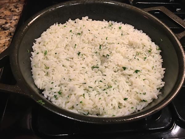 Skillet with basmati rice and chopped parsley.