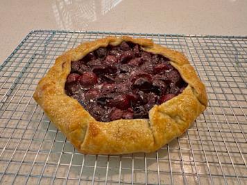 A cherry galette on a baking rack.