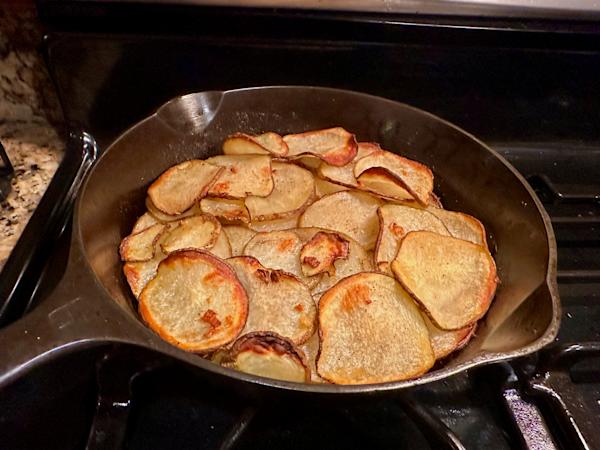 A skillet with layers of potato in a galette.