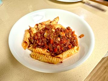 A plate of garganelli with sausage ragu.