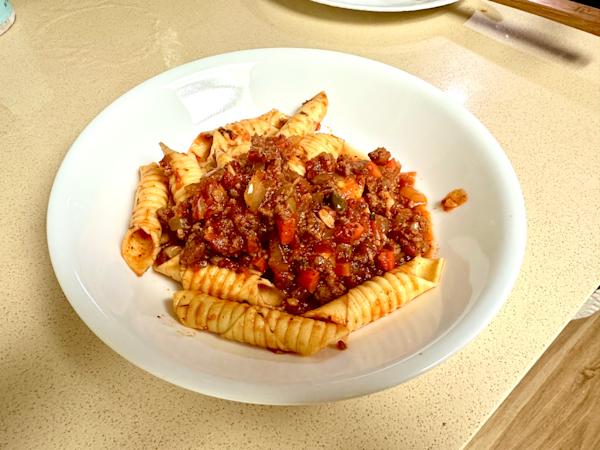 A plate of garganelli with sausage ragu.