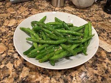 a bowl of green beans sautéed with garlic, lemon, and dill.