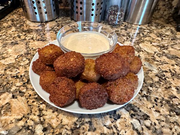 A plate of falafel with tahini sauce.
