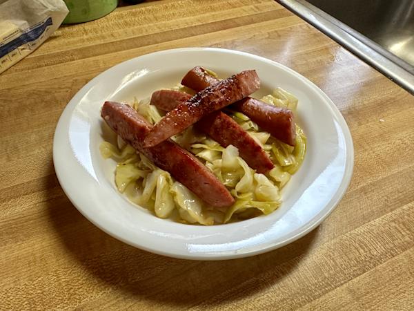 A plate of kielbasa and sautéed cabbage.