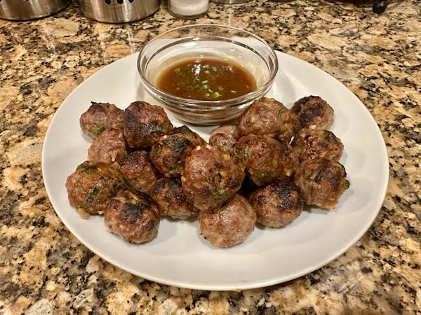 A plate of bulgoki meatballs with dipping sauce.