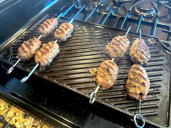 Kafta skewers on a grill.