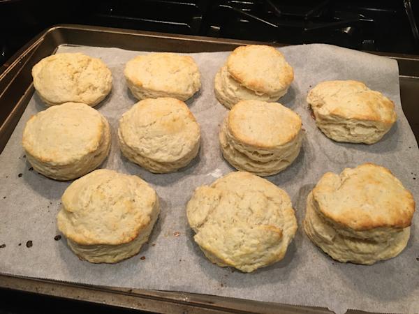 A batch of baking soda biscuits on a parchment-lined baking sheet.