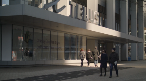 People walking in front of Telus office building