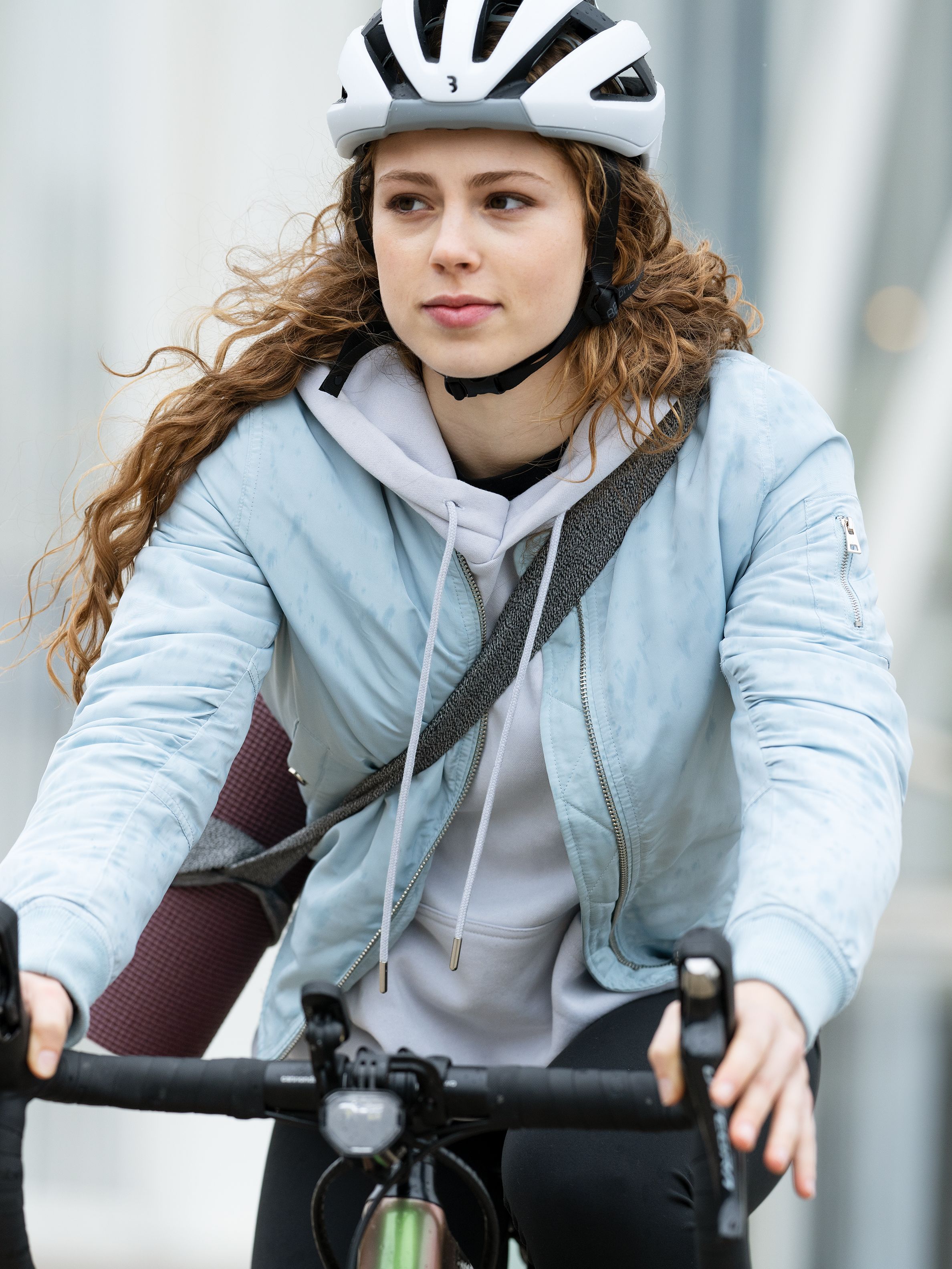 Junge Frau mit Helm die Fahrrad fährt.