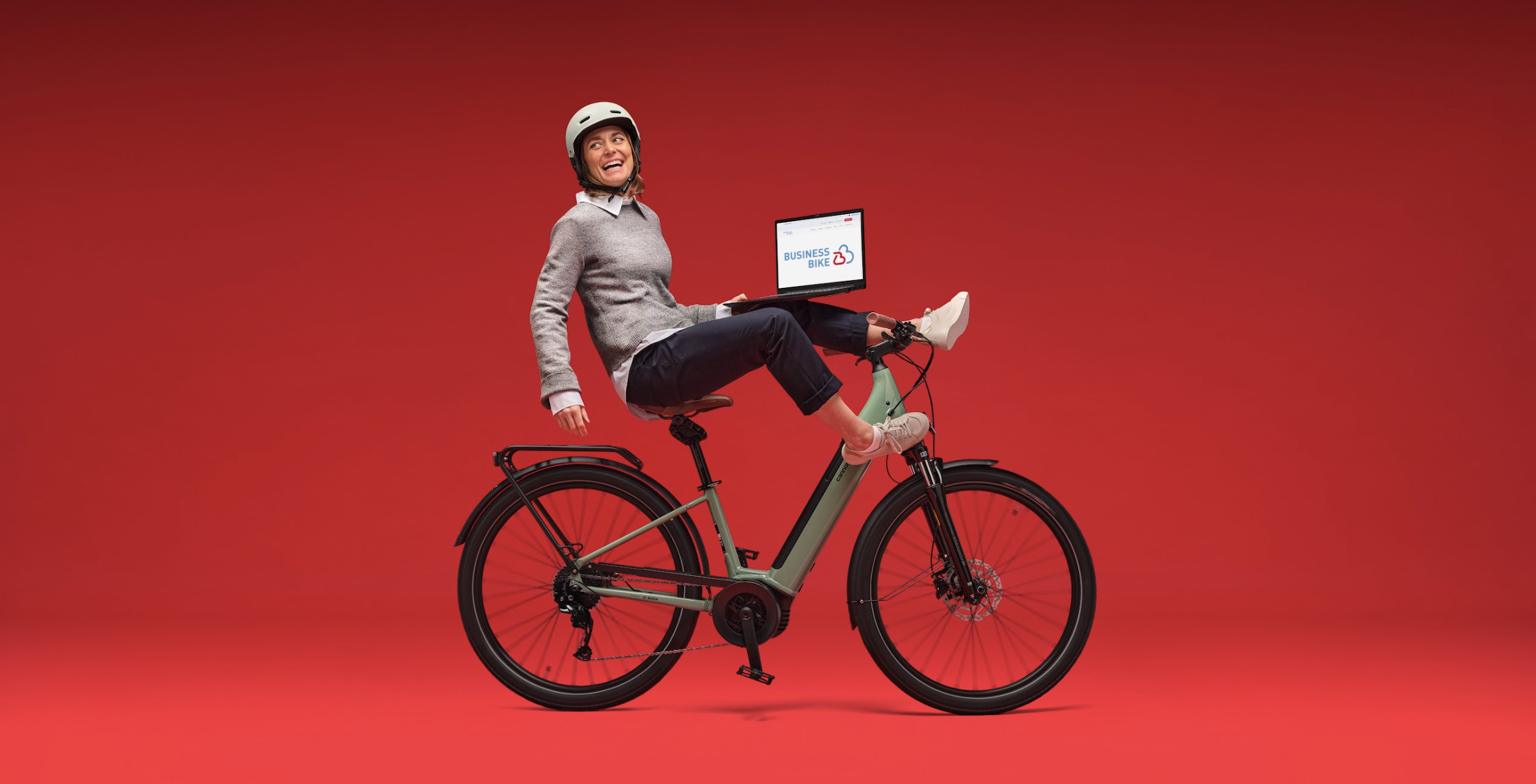 Frau mit Laptop auf Fahrrad