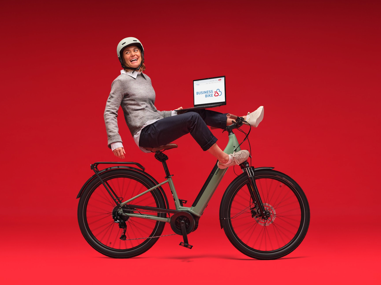 Frau mit Laptop auf Fahrrad