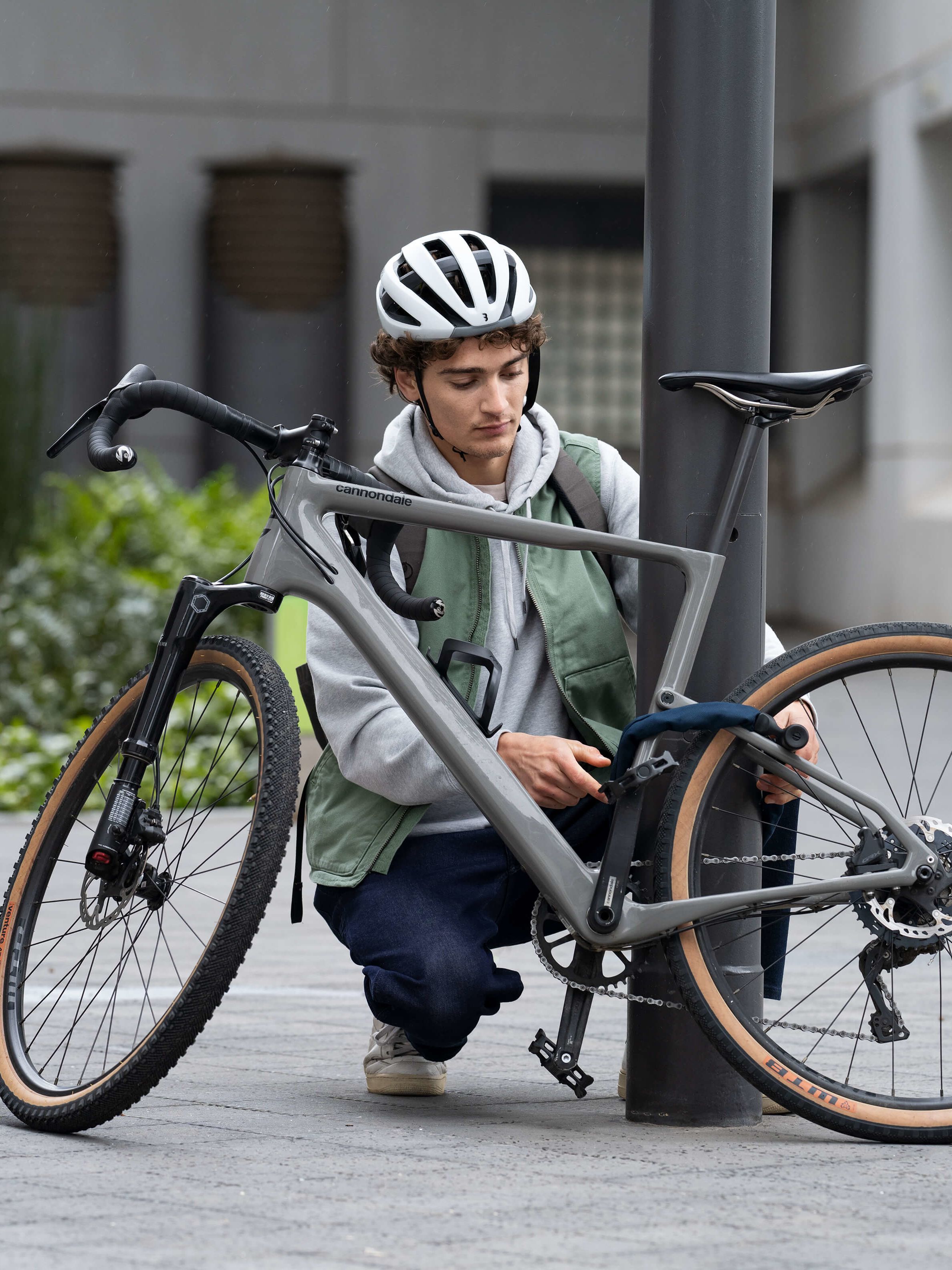 Junge mit Helm, der sein Fahrrad anschließt.