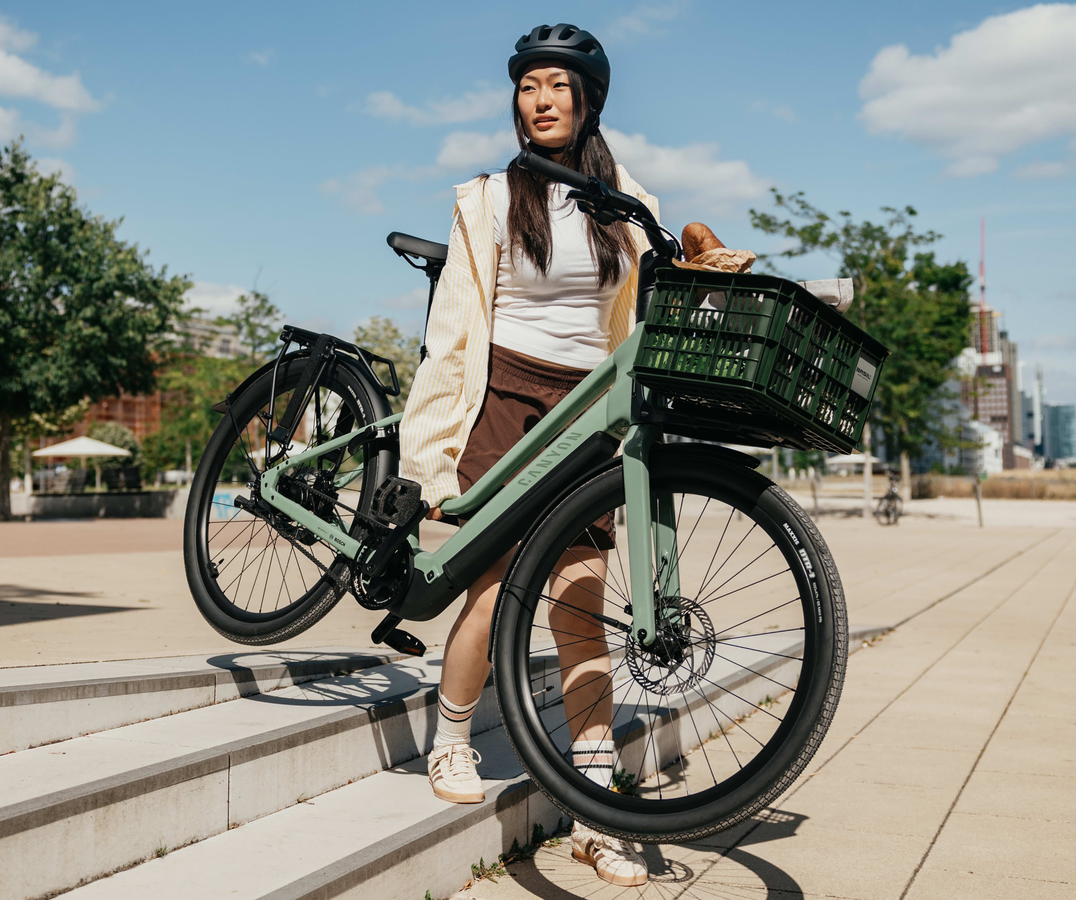 Frau in der Stadt mit E-Bike von Canyon
