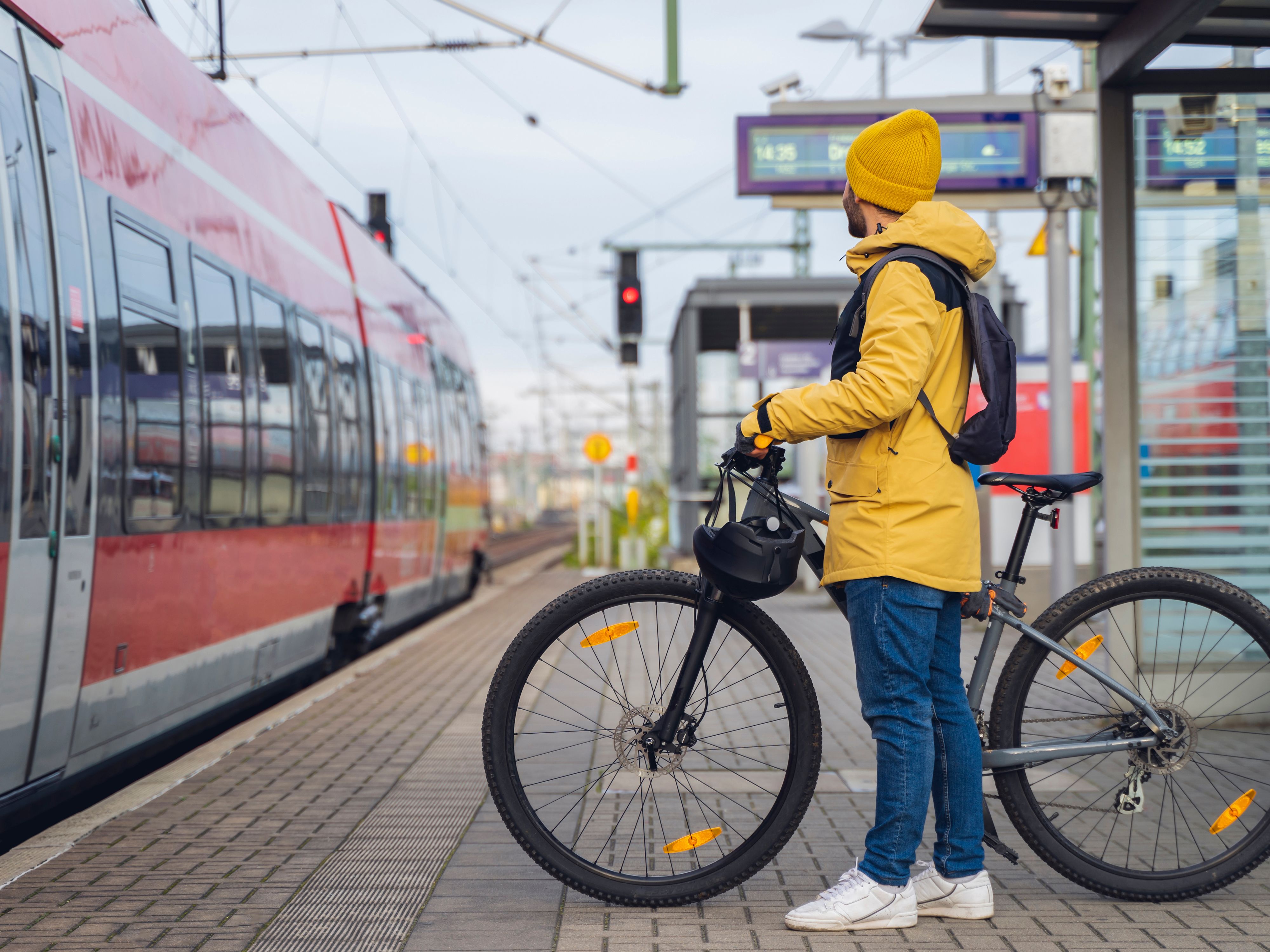 Mann mit Fahrrad der in einen Zug einsteigen möchte