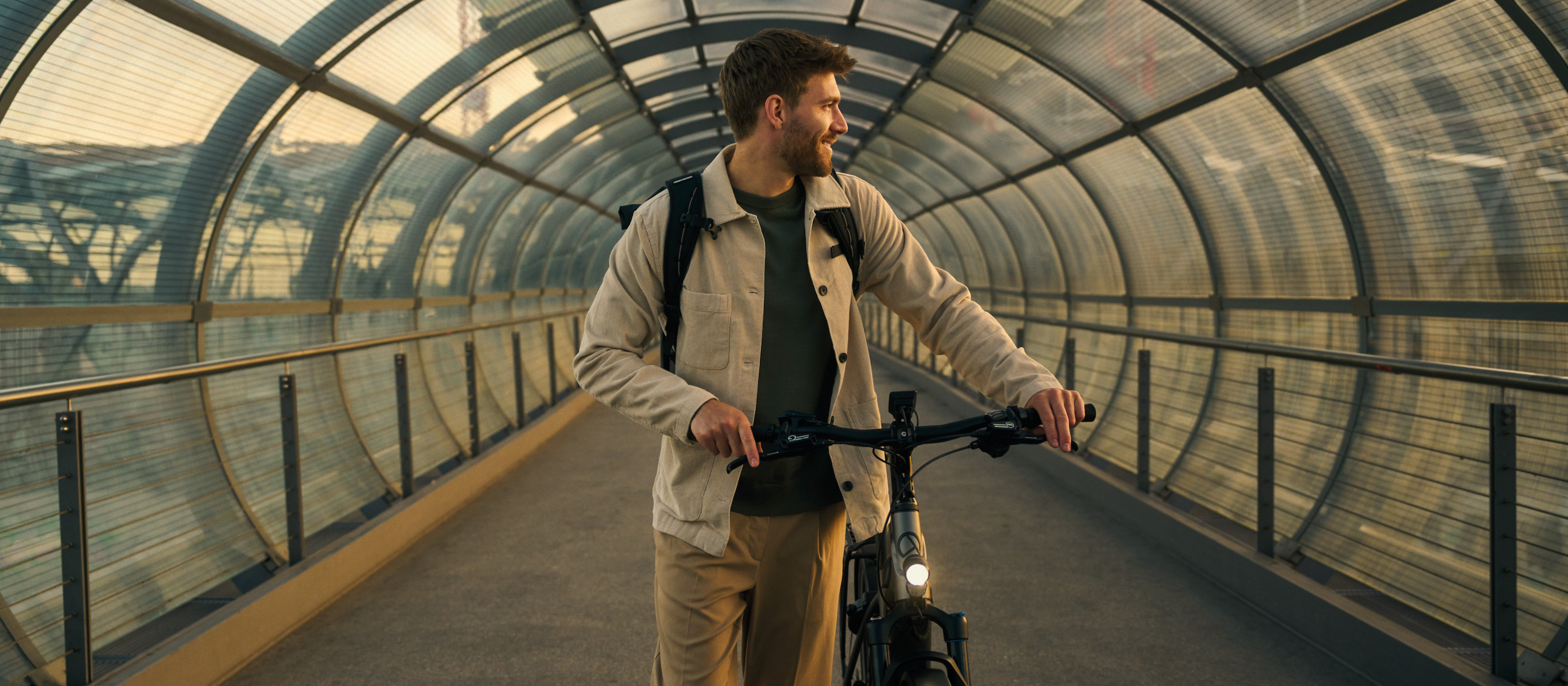 Mann der mit einerm Fahrrad durch einen Tunnel geht