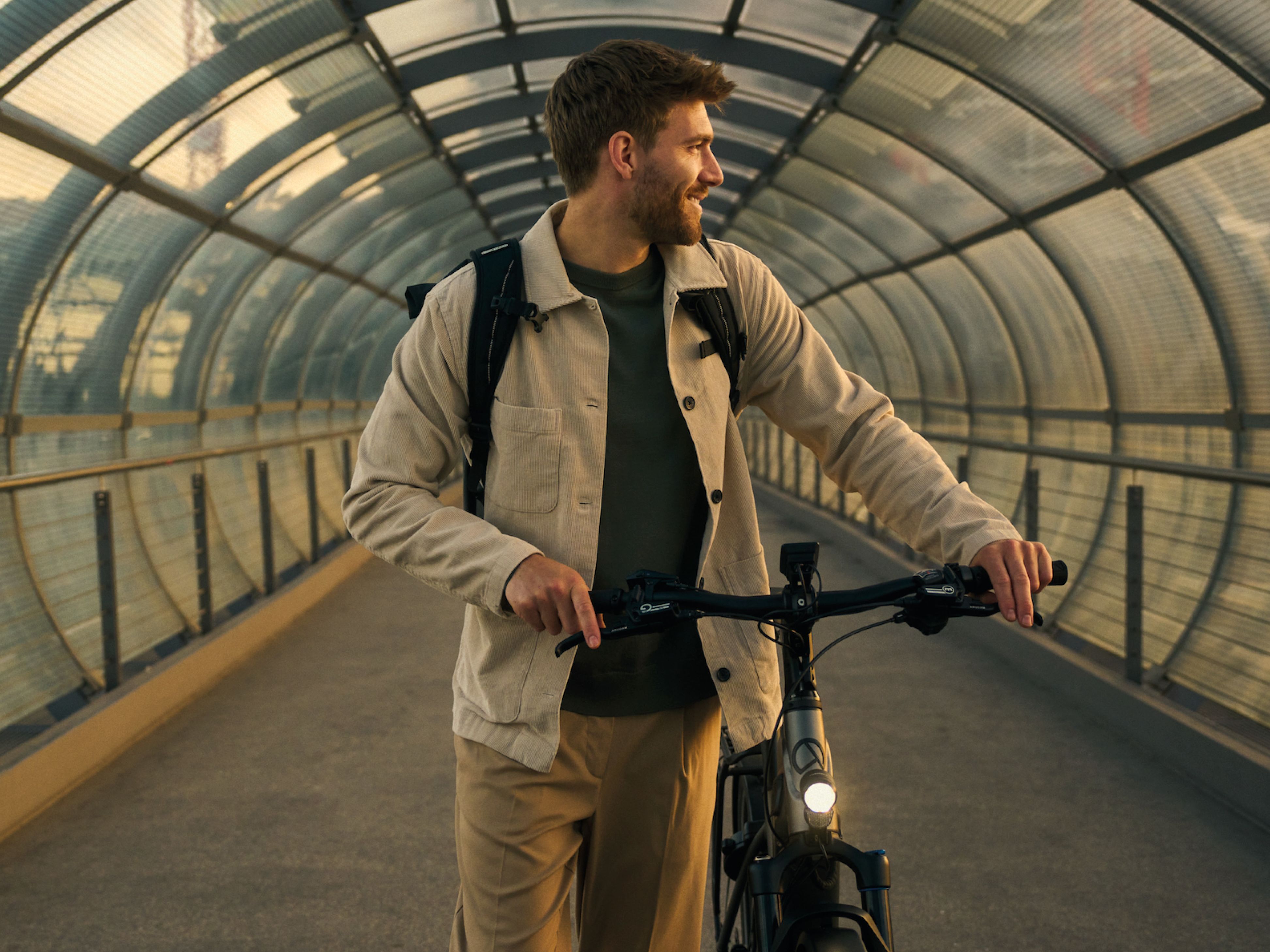 Mann der mit einerm Fahrrad durch einen Tunnel geht