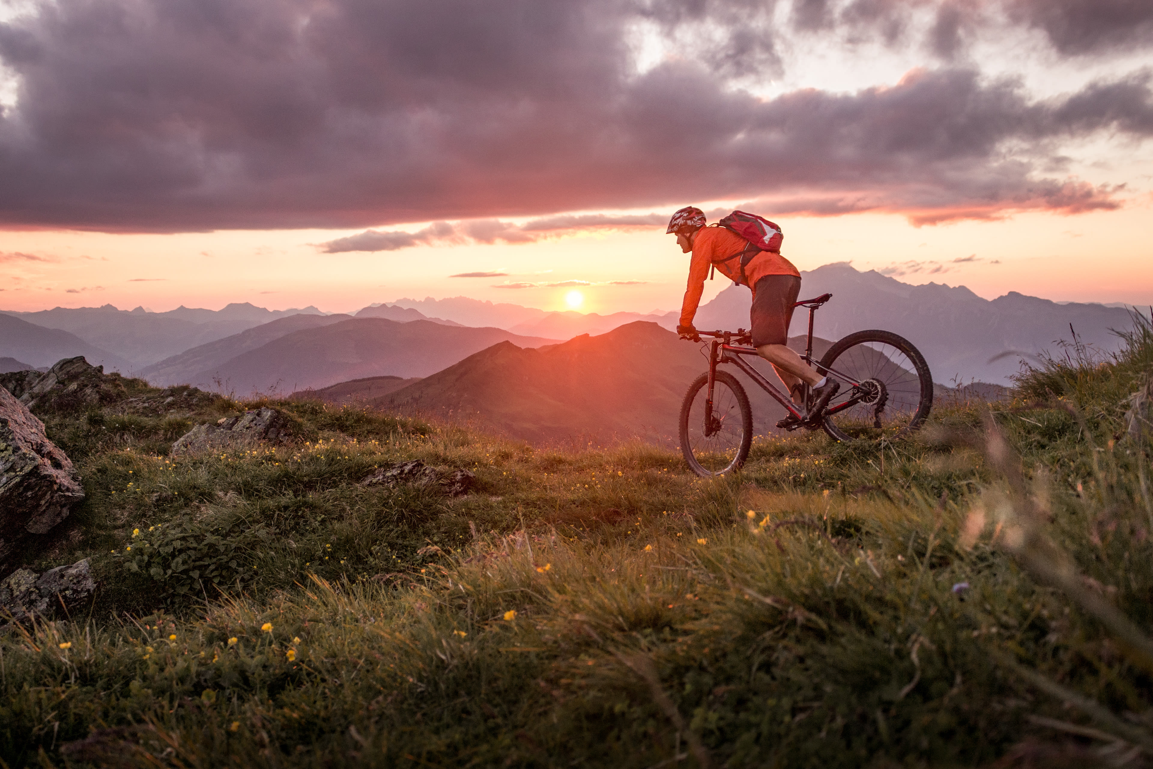 Sportlicher Fahrradfahrer in der Natur mit Abenddämmerung im Hintergrund