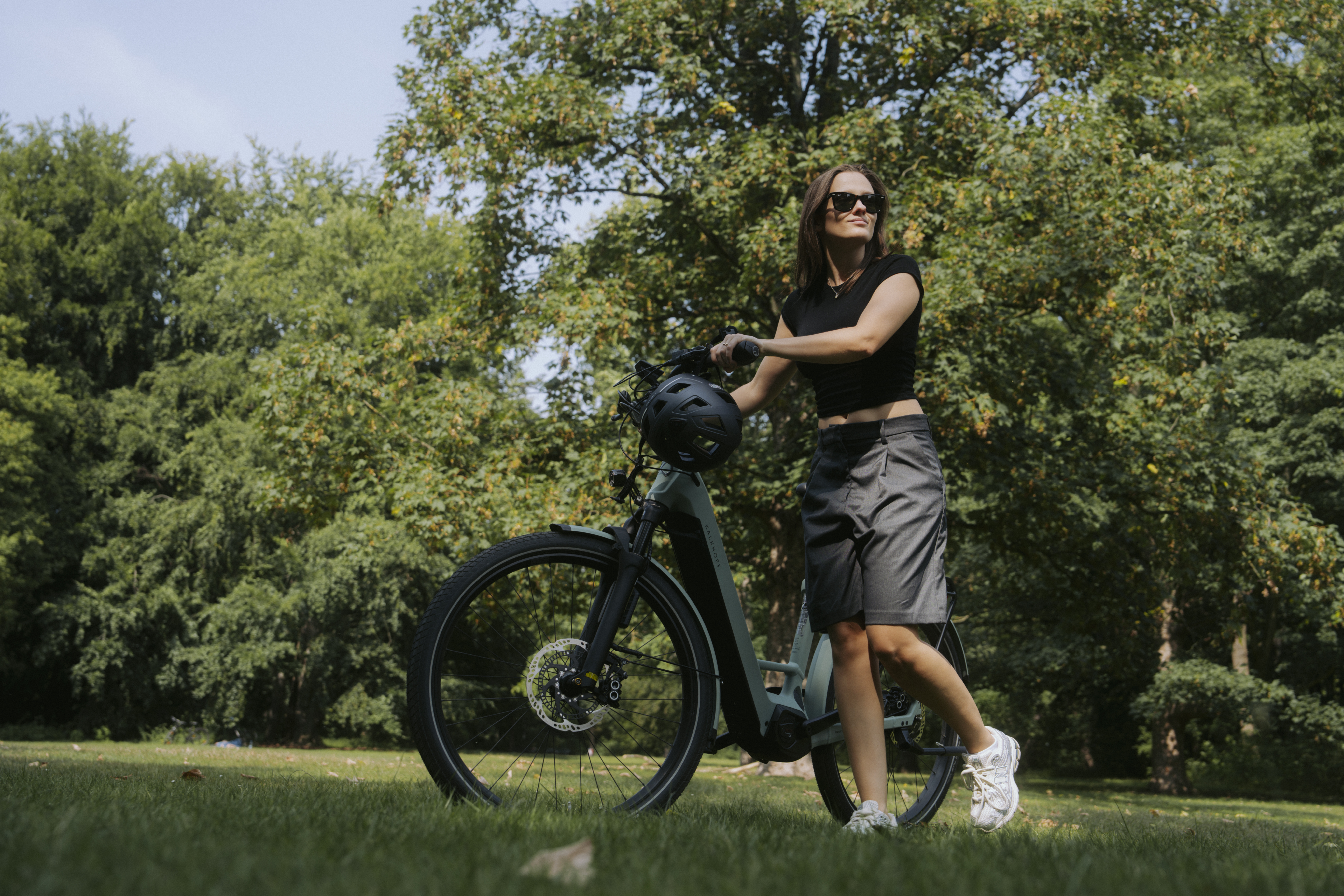 Junge Frau in professioneller Fahrradbekleidung posiert mit ihrem Rad,
