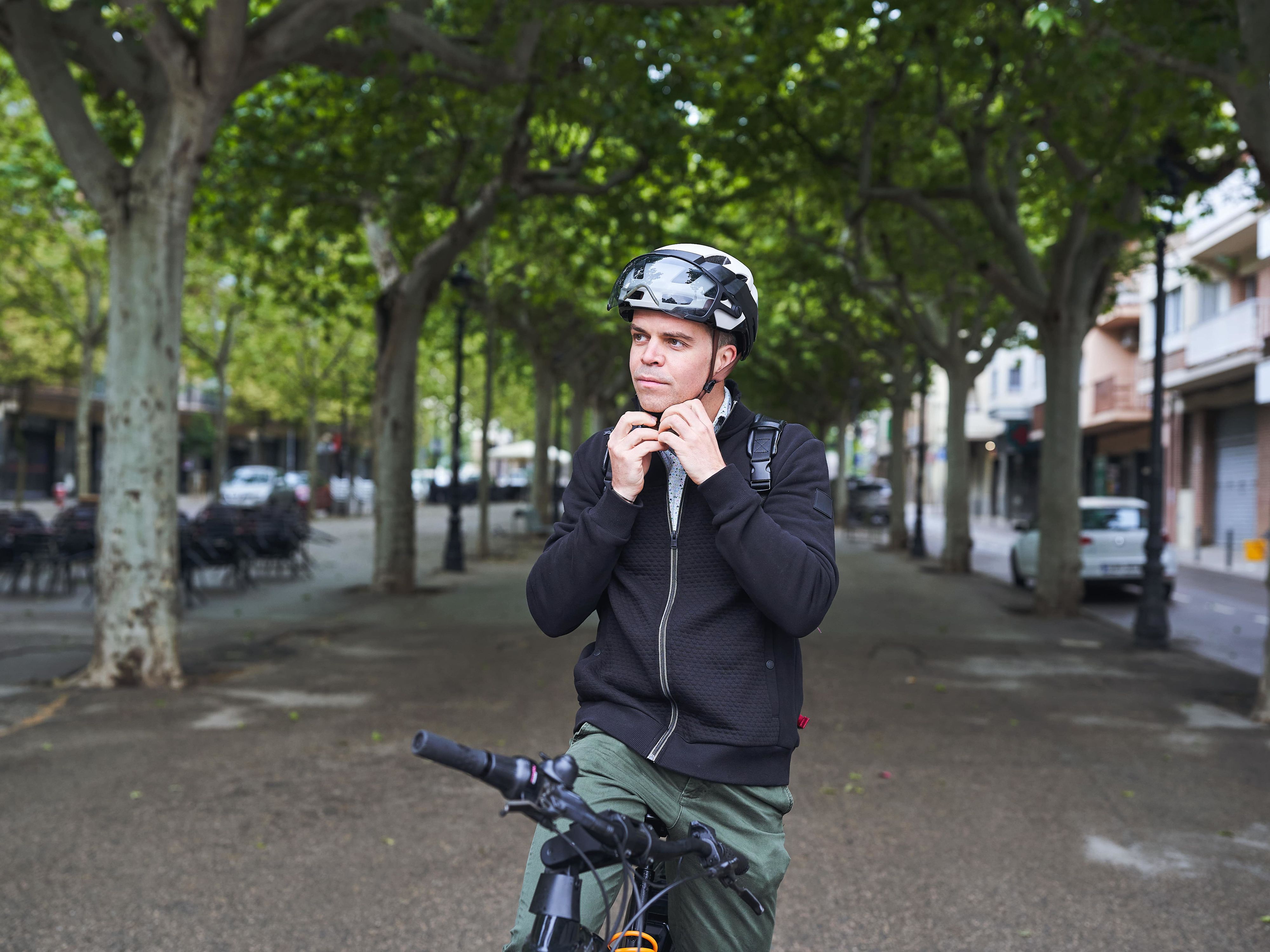 Mann schließt seinen E-Bike-Helm vor der Fahrt