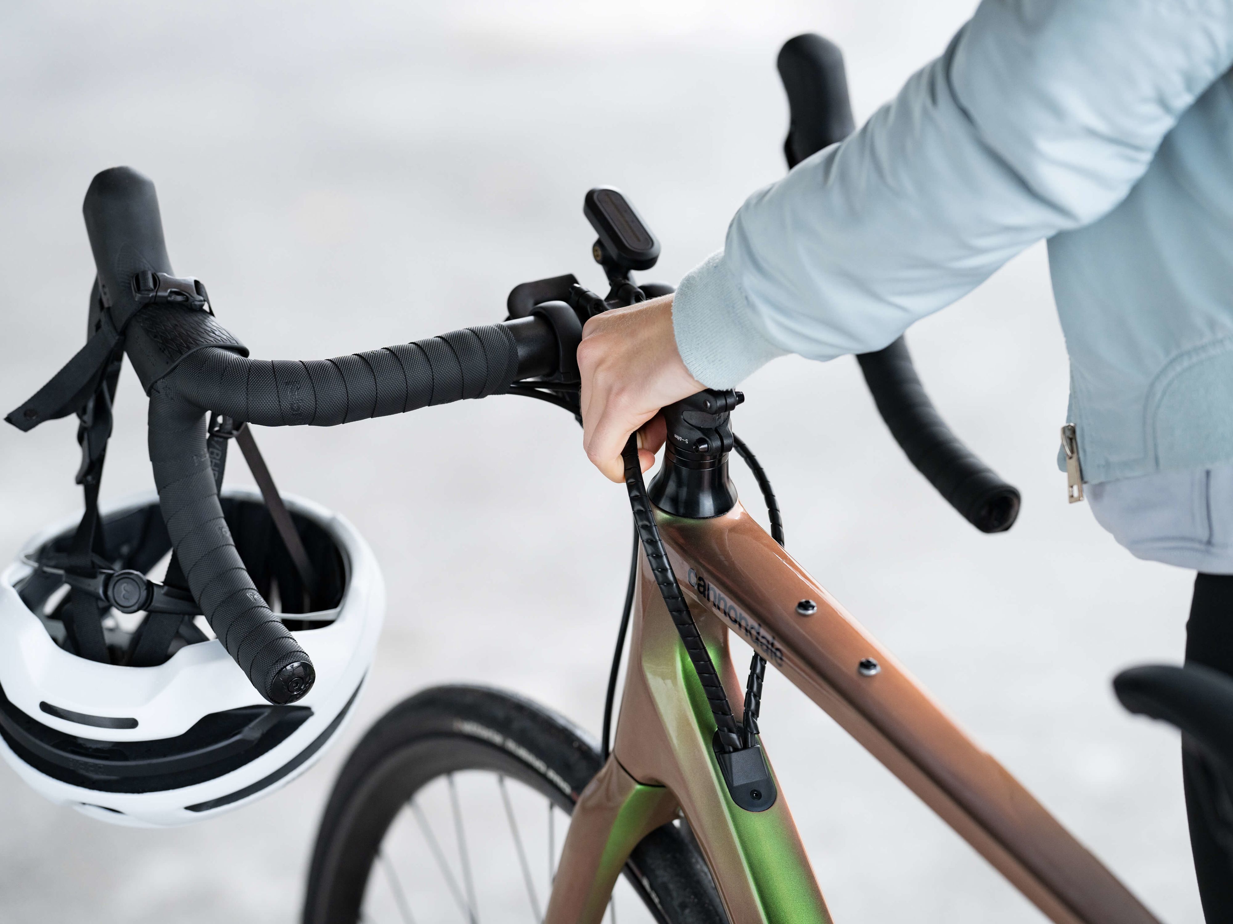 Fahrrad, das am Lenker gehalten wird. Ein Fahrradhelm ist daran befestigt.