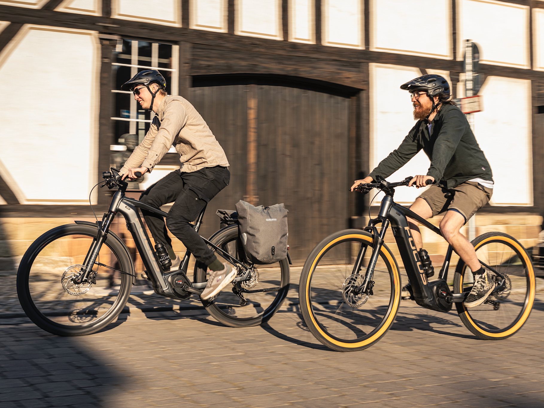 Zwei Männer auf dem E-Bike treten in die Pedale