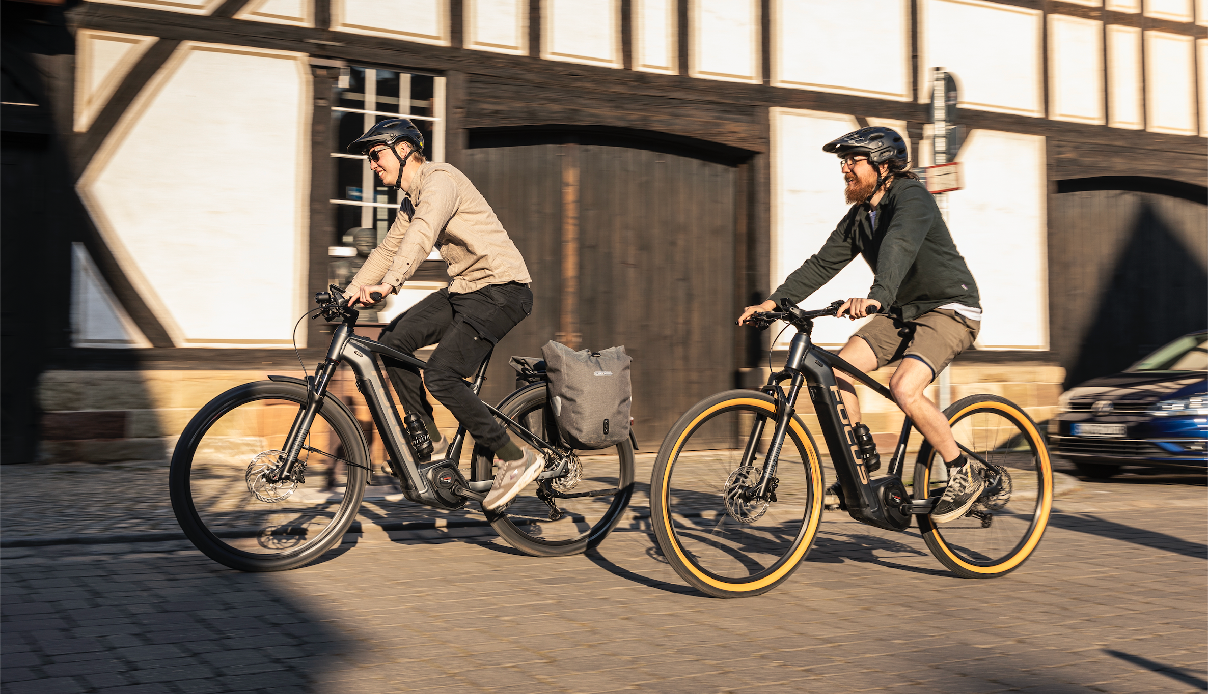Zwei Männer auf dem E-Bike treten in die Pedale