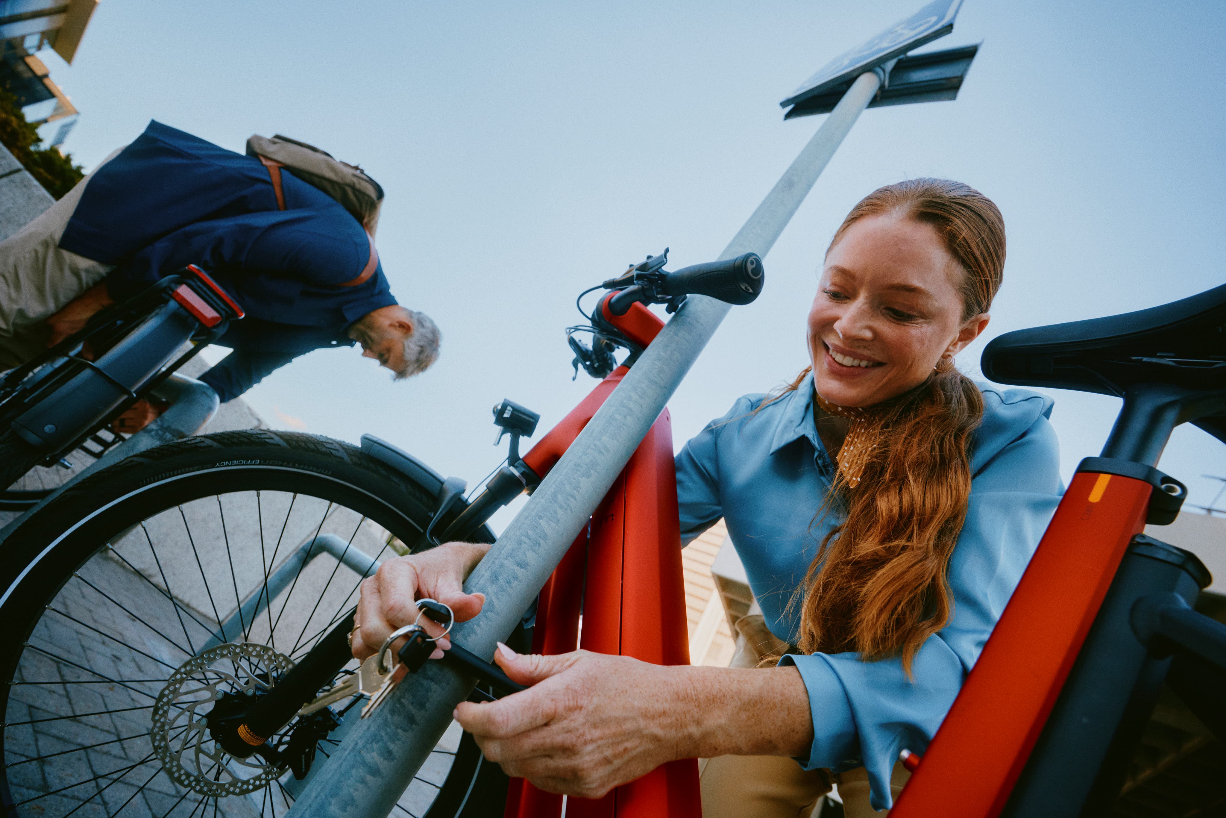 Frau die ihr Fahrrad mit einem Schloss sichert