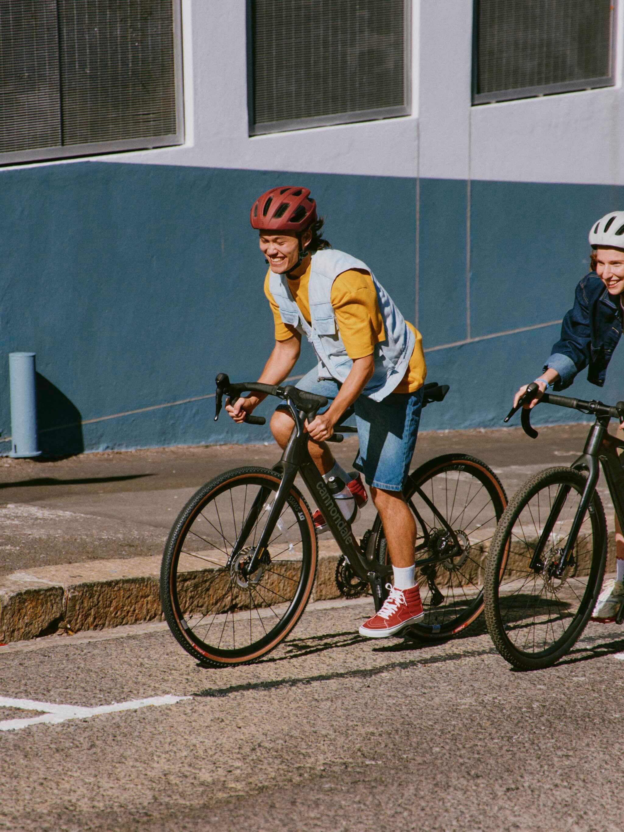 Fahrrad, das am Lenker gehalten wird. Ein Fahrradhelm ist daran befestigt.