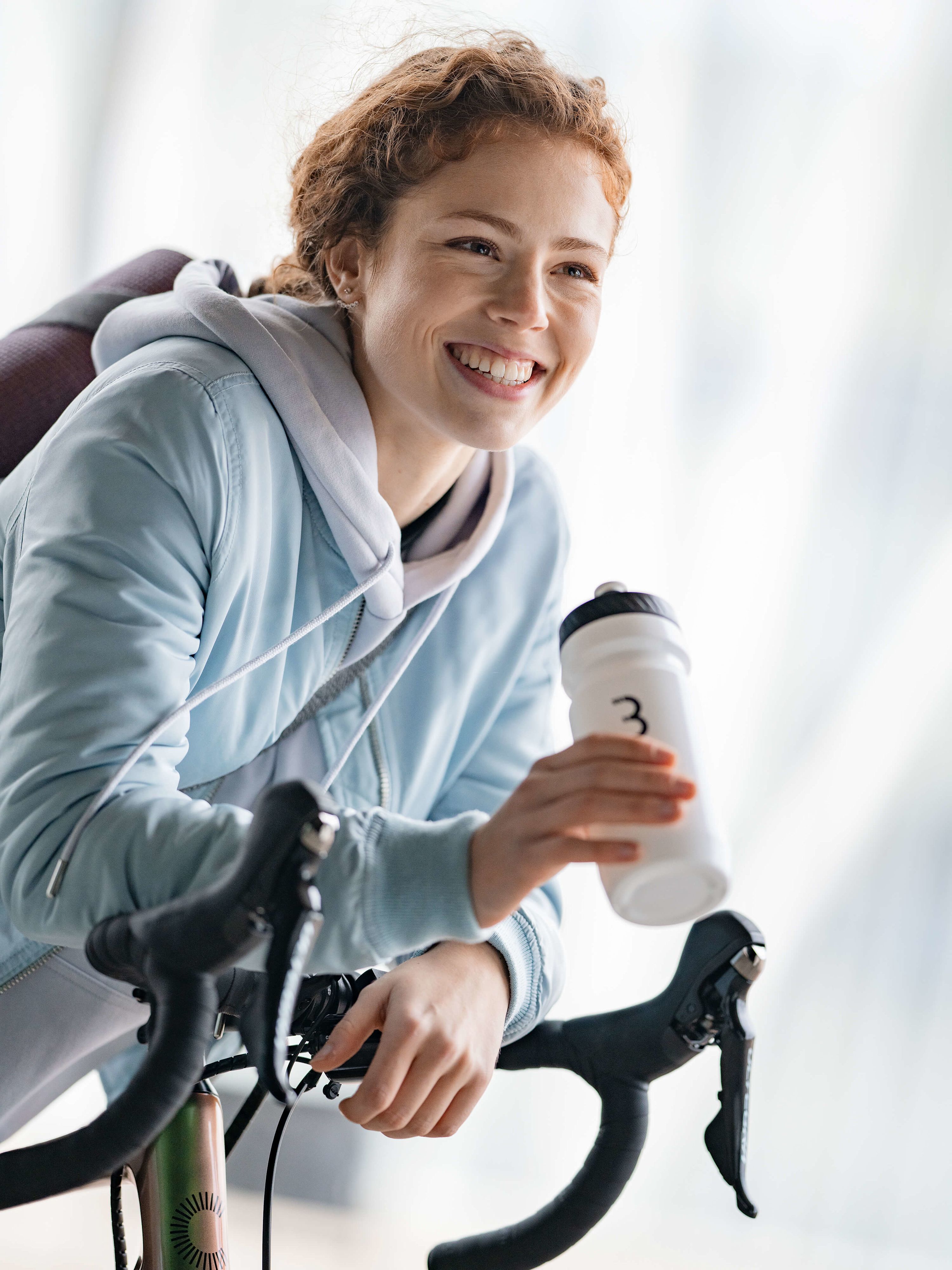 Junge Frau mit Trinkflasche in der Hand